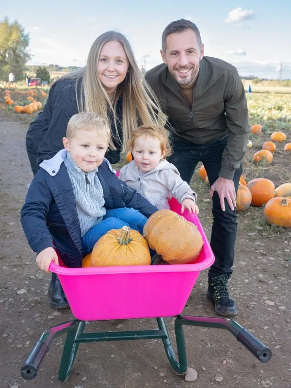 Family laughing together during an autumn session