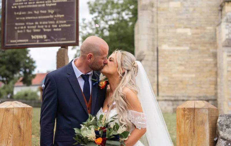 The couple share a kiss outside the church