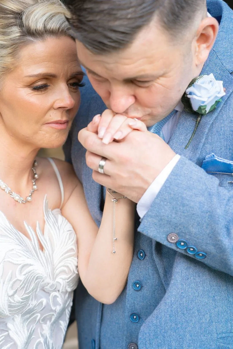The groom kisses the bride's hand
