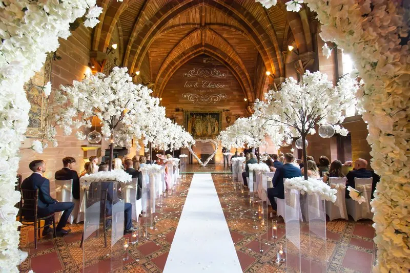 The ceremony aisle dressed in blossom and candlelight